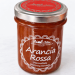 Marmellata di arancia rossa Sicilian Factory 240 g in vasetto di vetro su sfondo chiaro